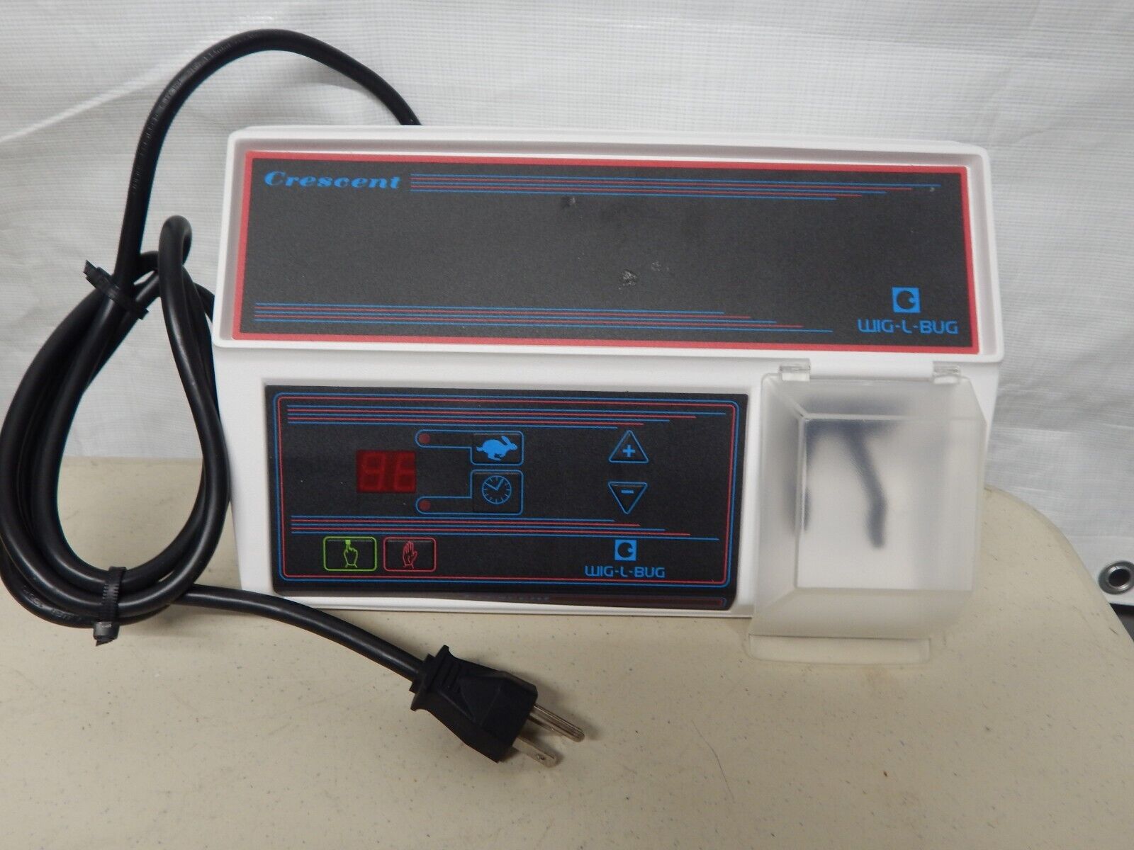 A white and blue electronic device with a cord.