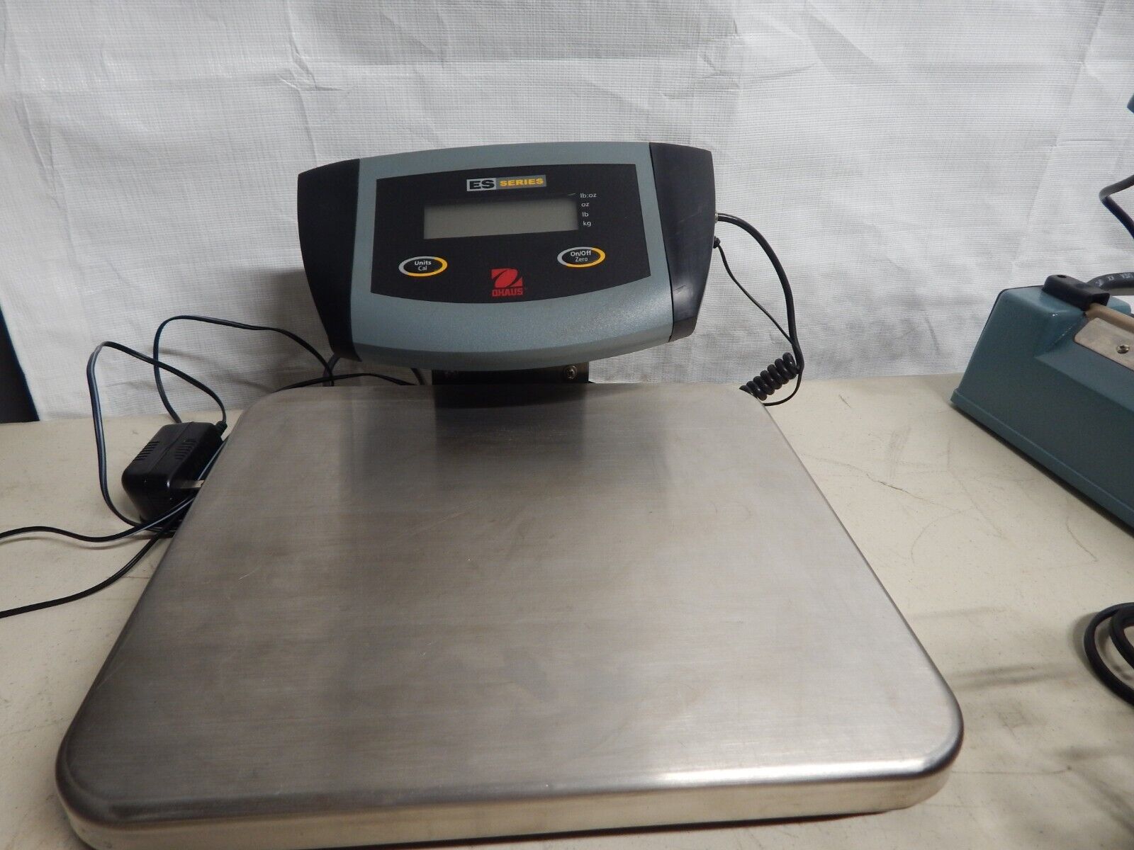 A digital shipping scale on a white table.