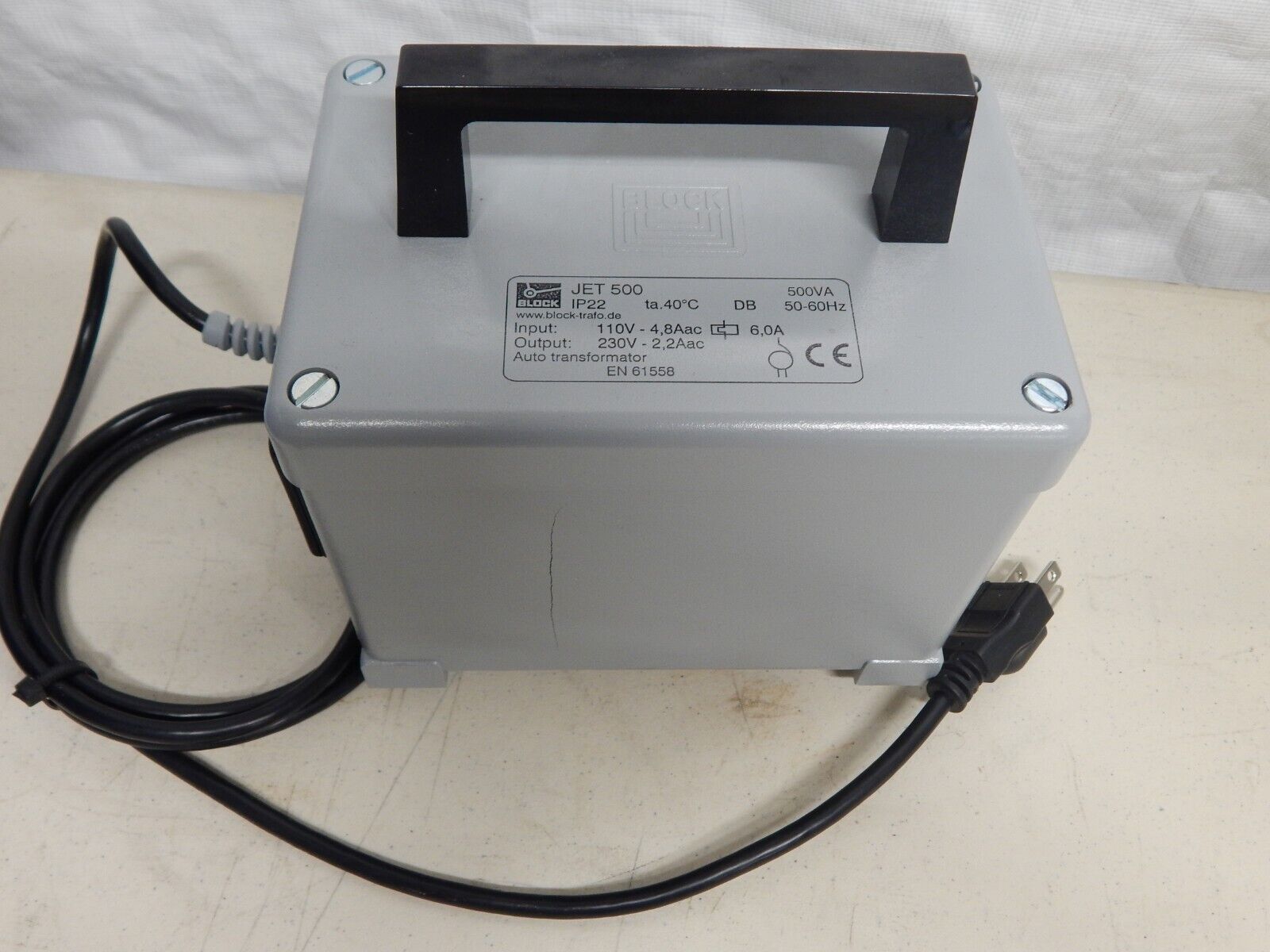 Black and gray electrical transformer with handle.
