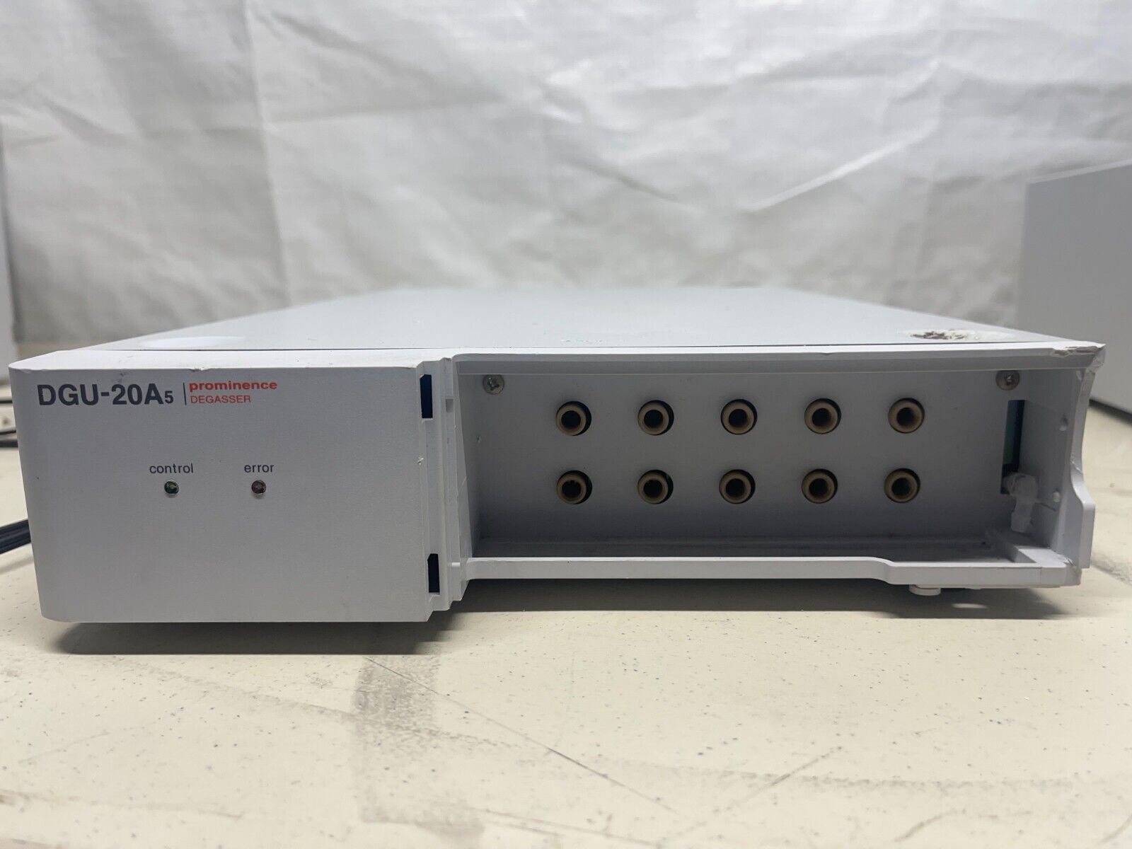 A white electronic device with black knobs and a red light.