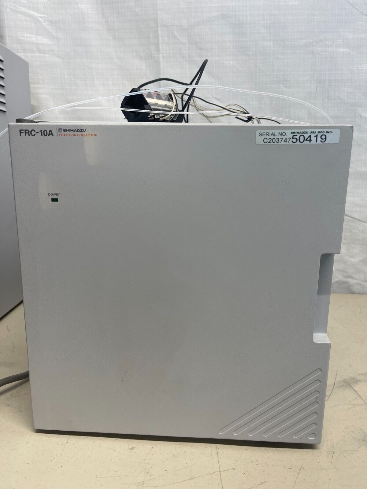 A gray box with a green power light and a label with text.