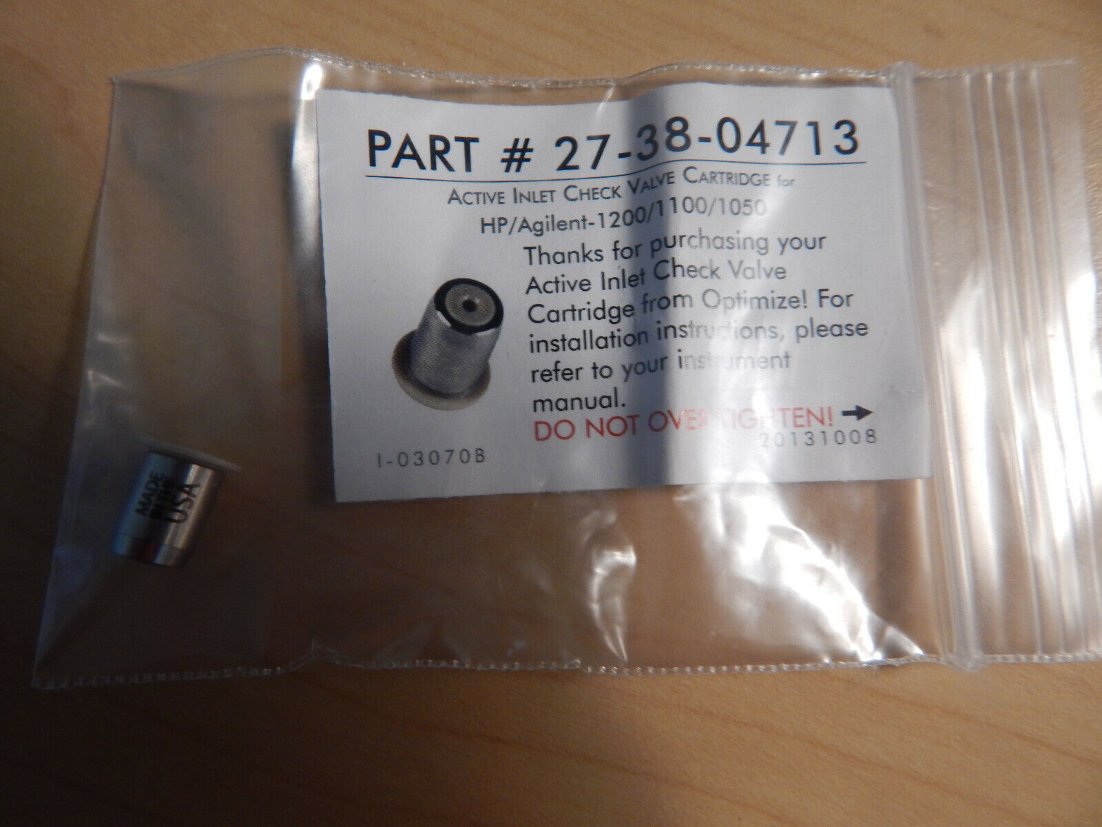 A small silver cylinder with a black label.