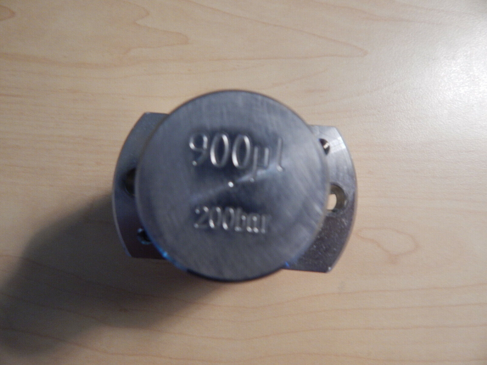 A metal disk with 900L and 200bar engraved on it.